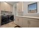 Well-equipped laundry room with modern washer, dryer, sink, and ample storage cabinets at 319 Belfast St, Henderson, NV 89015