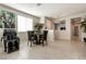 Dining area with tile floors, a glass-top table, and an open view to the living room, filled with natural light at 332 Coldwell Station Rd, North Las Vegas, NV 89084