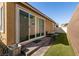 Outdoor patio with sliding glass doors, brick pavers, and a strip of artificial turf at 332 Coldwell Station Rd, North Las Vegas, NV 89084