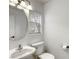 Cozy powder room with a round mirror and window for natural light at 3650 Mcmurty Ct, Las Vegas, NV 89129