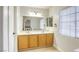 Bright bathroom with double sinks, wooden cabinets, and large mirror at 3650 Mcmurty Ct, Las Vegas, NV 89129