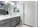 A bathroom shows a vanity with a large mirror, a sink, gray cabinets, and a white door at 4300 Del Monte Ave, Las Vegas, NV 89102