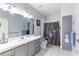 A bathroom features a large mirror, gray cabinets, a shower with a curtain, and accessibility equipment at 4300 Del Monte Ave, Las Vegas, NV 89102