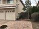 Beige two car garage with neutral colored brick driveway and desert landscaping at 4481 Grey Spencer Dr, Las Vegas, NV 89141