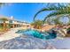 Beautiful backyard pool with rock waterfall feature, surrounded by palm trees and lush landscaping at 4481 Grey Spencer Dr, Las Vegas, NV 89141