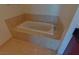 Elegant bathroom showcasing a white soaking tub with marble surround and tile flooring at 4575 Dean Martin Dr # 1201, Las Vegas, NV 89103