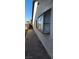 Side view of home featuring neutral stucco exterior, window, and concrete walkway at 503 Crony Ave, Henderson, NV 89011