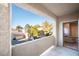 Balcony view overlooking lush trees and townhouses with a clear blue sky, and a glimpse of the interior at 5250 S Rainbow Blvd # 2033, Las Vegas, NV 89118