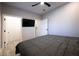 Modern bedroom featuring light gray walls, wood-look floors, with ceiling fan and television at 5250 S Rainbow Blvd # 2033, Las Vegas, NV 89118