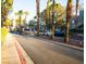 A well maintained street view to a condo entrance with guard booth, palm trees and parked cars at 5250 S Rainbow Blvd # 2033, Las Vegas, NV 89118