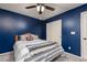 Comfortable bedroom featuring a ceiling fan, natural light, a comfortable bed, and blue accent wall at 5609 Hannah Gordon Ct, North Las Vegas, NV 89081