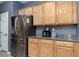 Kitchen area with wooden cabinets, granite countertops, and stainless steel refrigerator at 5609 Hannah Gordon Ct, North Las Vegas, NV 89081