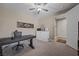 This bedroom has a ceiling fan, a desk and chair with decorative wall art and hall access at 571 Marilyn Pkwy # 4, Mesquite, NV 89027