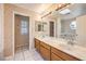 A bathroom with double sinks, marble countertops, decorative wallpaper and marble flooring at 5751 E Owens Ave, Las Vegas, NV 89110