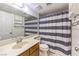 Bathroom featuring a vanity with a large mirror, toilet and shower with gray and white striped shower curtain at 5751 E Owens Ave, Las Vegas, NV 89110