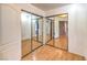 Hallway featuring double mirrored closets and wood laminate flooring at 5751 E Owens Ave, Las Vegas, NV 89110