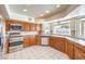 Bright kitchen featuring stainless steel appliances, tile countertops, and ample natural light from bay window at 5751 E Owens Ave, Las Vegas, NV 89110