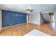 Spacious living room featuring hardwood floors, ceiling fan, and a striking blue accent wall at 5751 E Owens Ave, Las Vegas, NV 89110