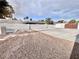 Enclosed backyard featuring rock landscaping, privacy wall, palm trees, and open space at 60 E Levi Ave, Las Vegas, NV 89183