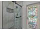 Modern glass shower with a rainfall showerhead, built-in niche, and decorative pebble floor accents at 60 E Levi Ave, Las Vegas, NV 89183
