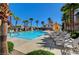 Relaxing community pool surrounded by palm trees and comfortable lounge chairs and tables at 6255 W Arby Ave # 193, Las Vegas, NV 89118