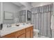 Bathroom with a double sink vanity, large mirror, and a shower with decorative curtains at 8286 Skye Gorge St, Las Vegas, NV 89166