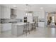 Modern kitchen with stainless steel appliances, white cabinetry, an island with bar seating, and tile flooring at 8286 Skye Gorge St, Las Vegas, NV 89166