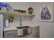 Modern laundry area with a large stainless steel sink and plenty of storage on open shelving at 8286 Skye Gorge St, Las Vegas, NV 89166