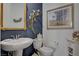 Charming powder room featuring decorative elements, a stylish mirror, and a pedestal sink at 8286 Skye Gorge St, Las Vegas, NV 89166