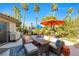 Outdoor patio with comfortable seating, umbrellas, and views of the beautifully landscaped backyard at 8620 Cremona Dr, Las Vegas, NV 89117