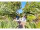 Secluded backyard patio with a cozy stone fire pit and surrounded by lush greenery at 8620 Cremona Dr, Las Vegas, NV 89117