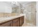 Bathroom with double vanity, elegant countertop, framed mirrors, and glass shower at 8620 Cremona Dr, Las Vegas, NV 89117