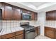 Kitchen showcasing gas range, microwave, and tile countertops at 8620 Cremona Dr, Las Vegas, NV 89117