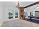 Bright living room featuring a brick fireplace, large windows, and a decorative chandelier at 8620 Cremona Dr, Las Vegas, NV 89117