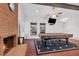 Inviting living room with a fireplace, exposed brick, pool table, and large windows at 8620 Cremona Dr, Las Vegas, NV 89117