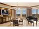 Formal dining area featuring a grand piano, decorative chandelier, and panoramic views from the large windows at 9103 Alta Dr # 602, Las Vegas, NV 89145