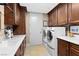Convenient laundry room with front load washer/dryer and ample storage in dark wood cabinets at 9103 Alta Dr # 602, Las Vegas, NV 89145