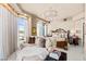 Serene main bedroom with a sitting area, plush bedding, chandelier, and expansive views through large windows at 9103 Alta Dr # 602, Las Vegas, NV 89145