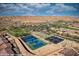 Aerial view of the community, highlighting tennis and pickle ball courts, landscaping, and desert mountain views at 950 Overland Trl, Mesquite, NV 89034