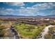 Expansive aerial view of the community, with a golf course, lush landscaping, and the mountains in the distance at 950 Overland Trl, Mesquite, NV 89034