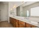 Bright bathroom featuring a double sink vanity, a large mirror, and a separate shower at 950 Overland Trl, Mesquite, NV 89034