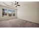Large carpeted bedroom with tray ceiling, ceiling fan, and plenty of natural light at 950 Overland Trl, Mesquite, NV 89034