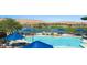 Picturesque community pool area with sun umbrellas, a lake, a golf course, and mountain views at 950 Overland Trl, Mesquite, NV 89034