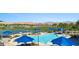 Resort-style community pool with shaded seating, a serene lake, and a well-maintained golf course in the background at 950 Overland Trl, Mesquite, NV 89034