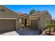 Attractive home exterior with a circular entryway, desert landscaping, and a three-car garage at 950 Overland Trl, Mesquite, NV 89034