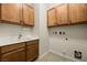 Well-lit laundry room features cabinets, sink, and tiled floors at 950 Overland Trl, Mesquite, NV 89034