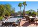 Relaxing backyard pool area with outdoor dining and lounge furniture, surrounded by beautiful palm trees and lush greenery at 950 Overland Trl, Mesquite, NV 89034