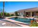 Backyard oasis featuring a pool, outdoor kitchen, palm trees, and serene landscaping at 950 Overland Trl, Mesquite, NV 89034
