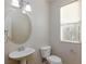 Bathroom featuring a pedestal sink, toilet, and a window with blinds at 1009 Ancient Timber Ave, Henderson, NV 89052