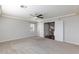 A large bedroom with plush carpeting, modern ceiling fan, and view to hallway and stairs at 1009 Ancient Timber Ave, Henderson, NV 89052